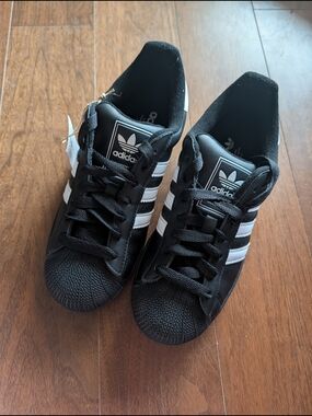 BELOVED ADIDAS SUPERSTAR SHOE WITH A CLASSIC ROUNDED SHELL TOE.